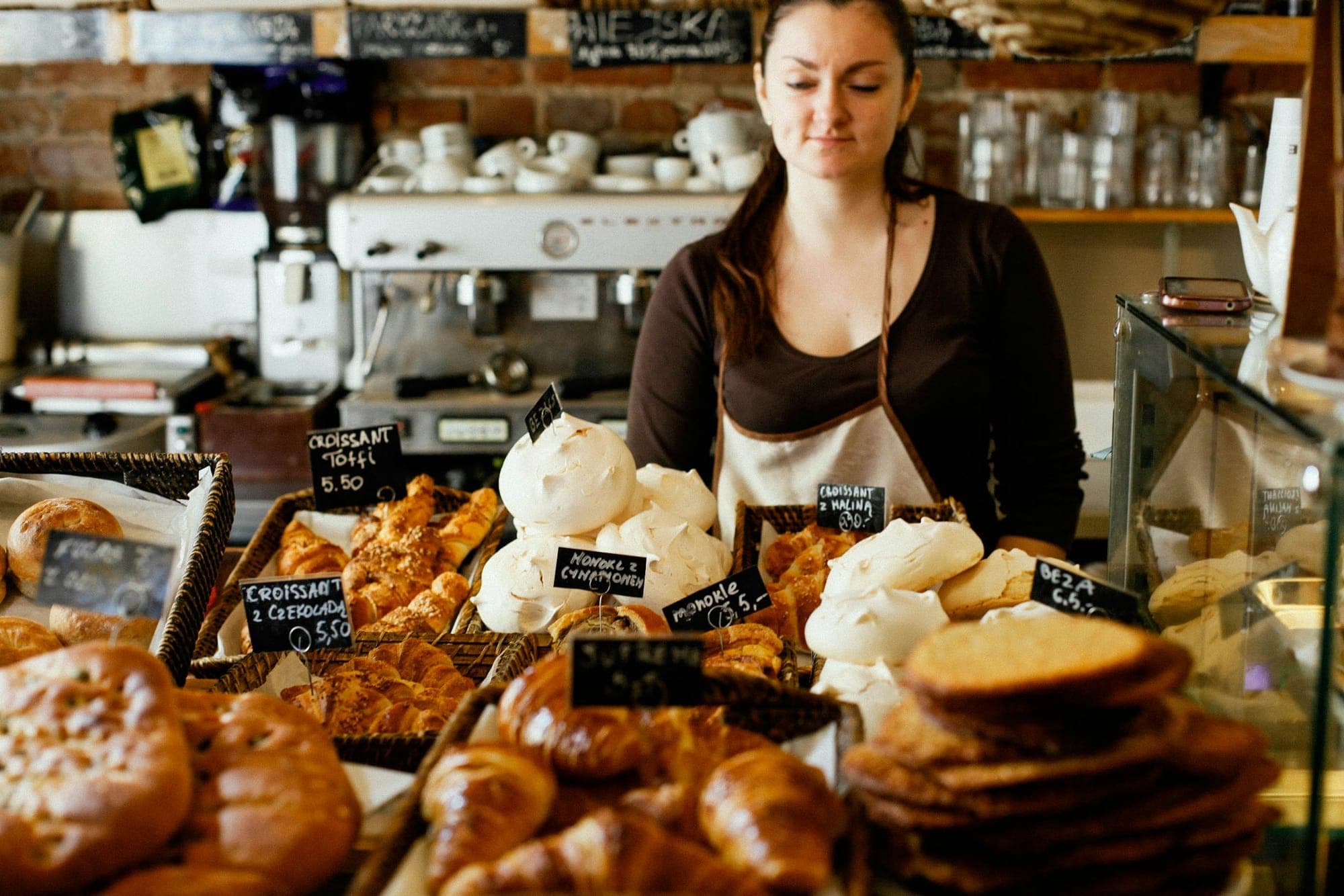 A café counter with pastries and handwritten price labels