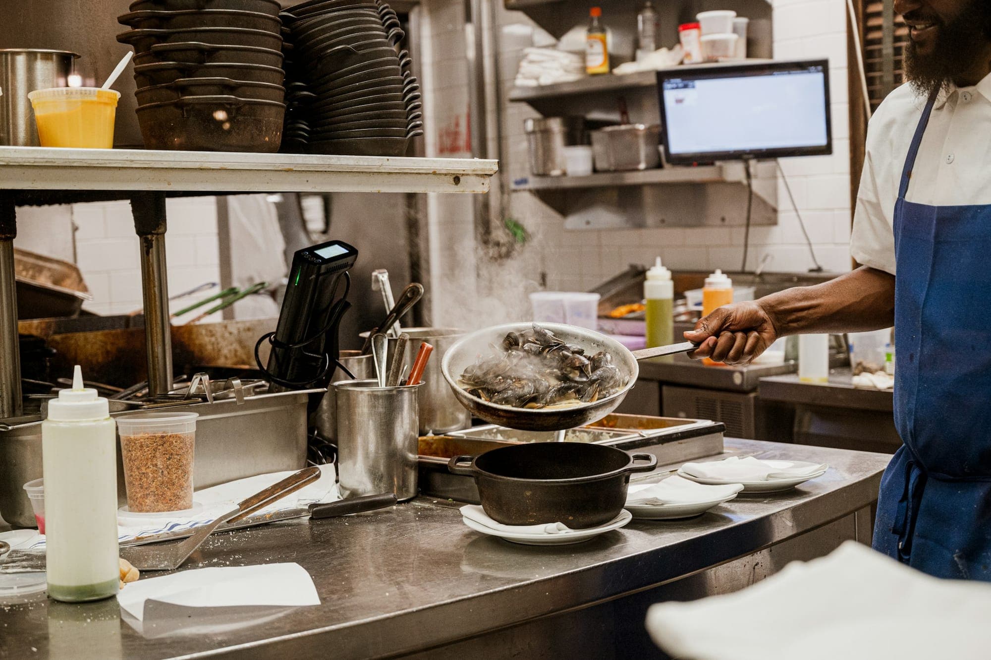 Pans and a hot plate at a busy kitchen pass